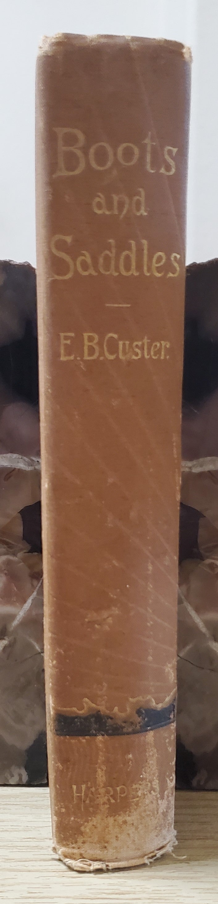 Custer, Elizabeth. Boots and Saddles. NY: Harper & Bros, 1885. 1st ed, 1st issue without a frontis or map. Pict cloth, gilt. Spine lean. Fraying, Cloth frayed. Bottom ½” spine soiled. Good